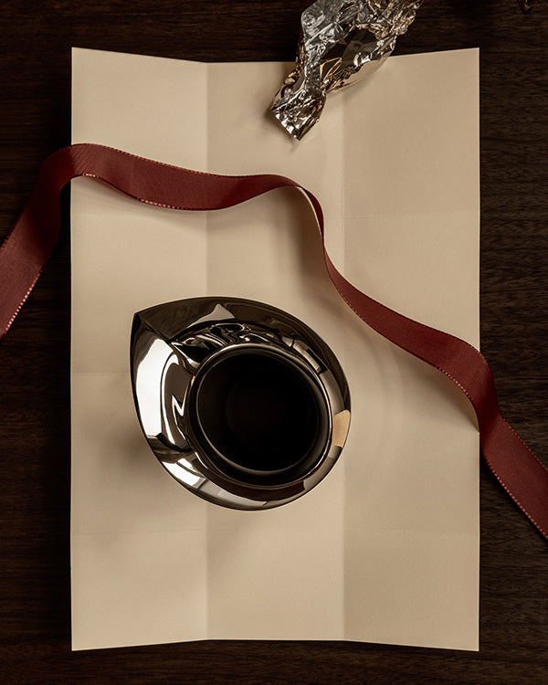 Pager with a red ribbon running across and the top view of a Silver pitcher