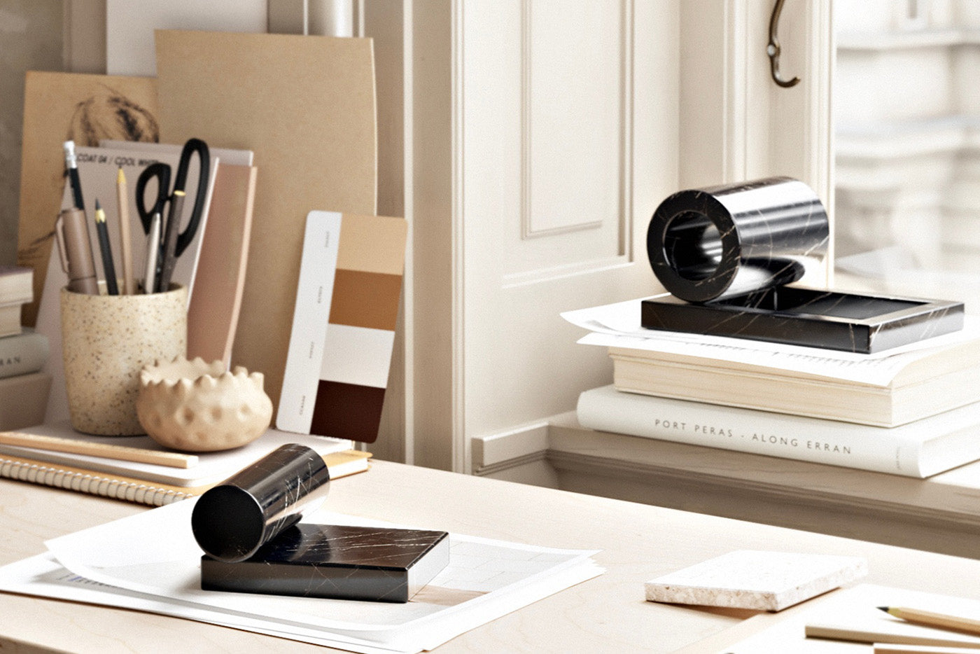 A cluttered desk with Marble paperweights from WOUD